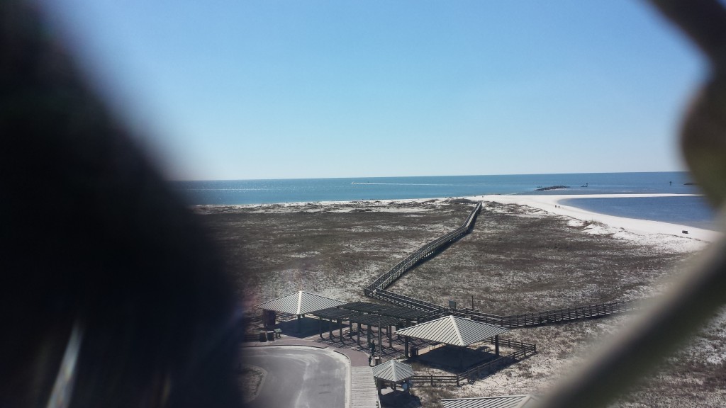 The beach at Gulf Shores Alabama. The dark blurry image on the left is the cyclone fence put up to keep everyone on the bridge.